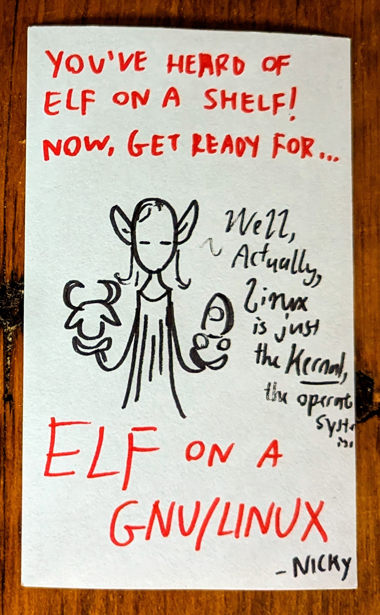 A marker drawing on paper. A wizard elf is shown meditating, holding the head of a gnu in one hand and a Linux penguin in the other. The elf trails off, saying "Well, actually, Linux is just the kernel, the operating system is..." The drawing is captioned in red marker: "You've heard of elf on a shelf! Now, get ready for... elf on a GNU/Linux." The drawing is signed "Nicky."